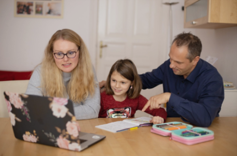 Parents helping child with learning on tablet